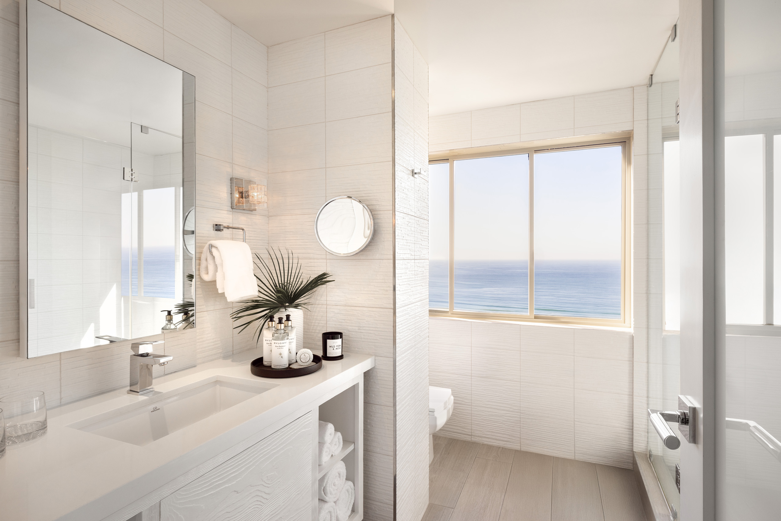 a well- lit hotel bathroom with an ocean view