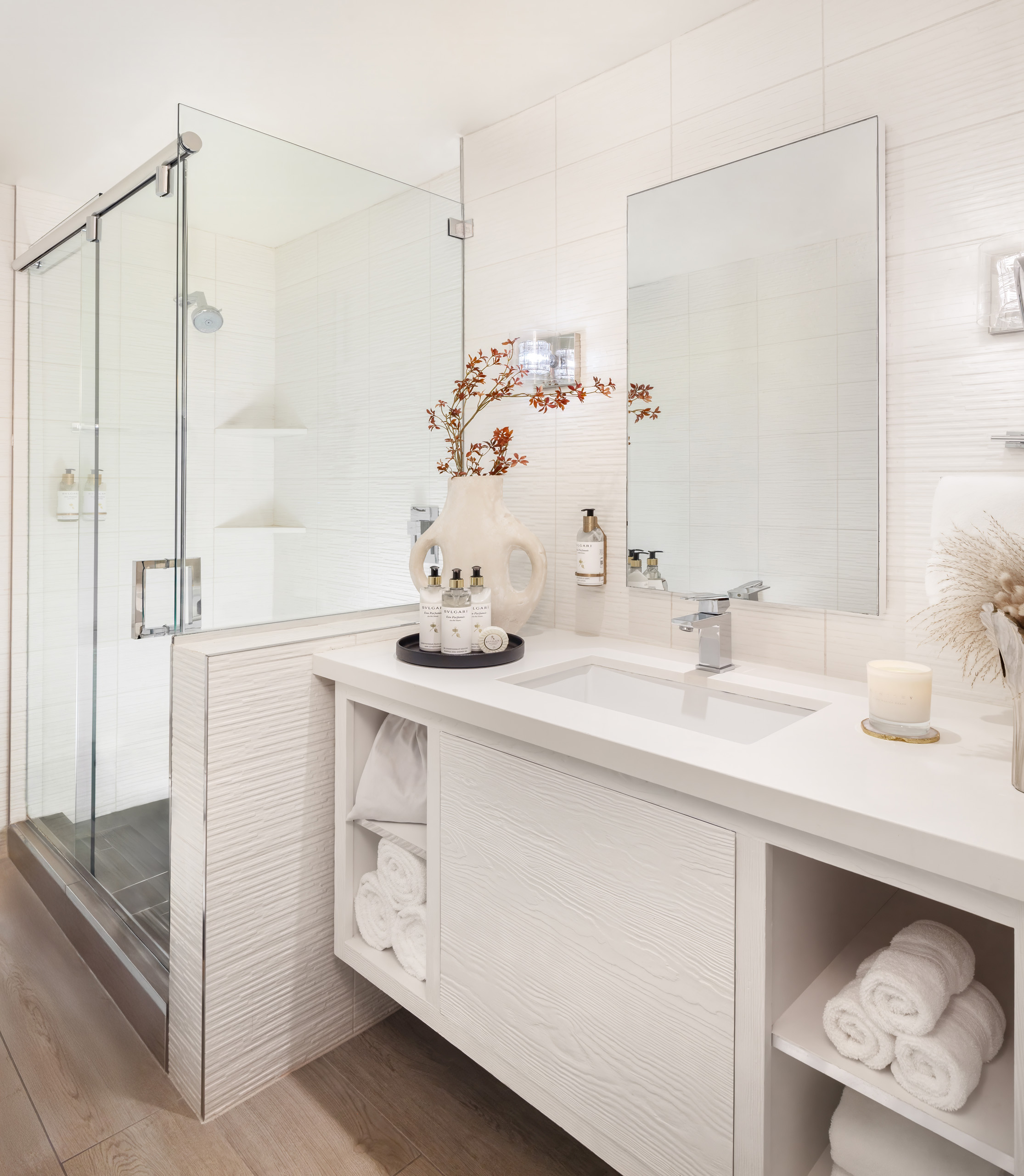 a hotel bathroom with white walls and countertops and modern fixtures