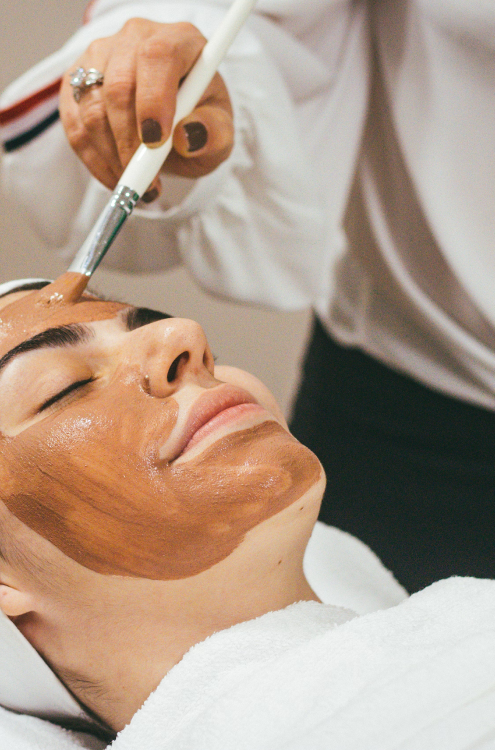woman receiving a mud mask facial
