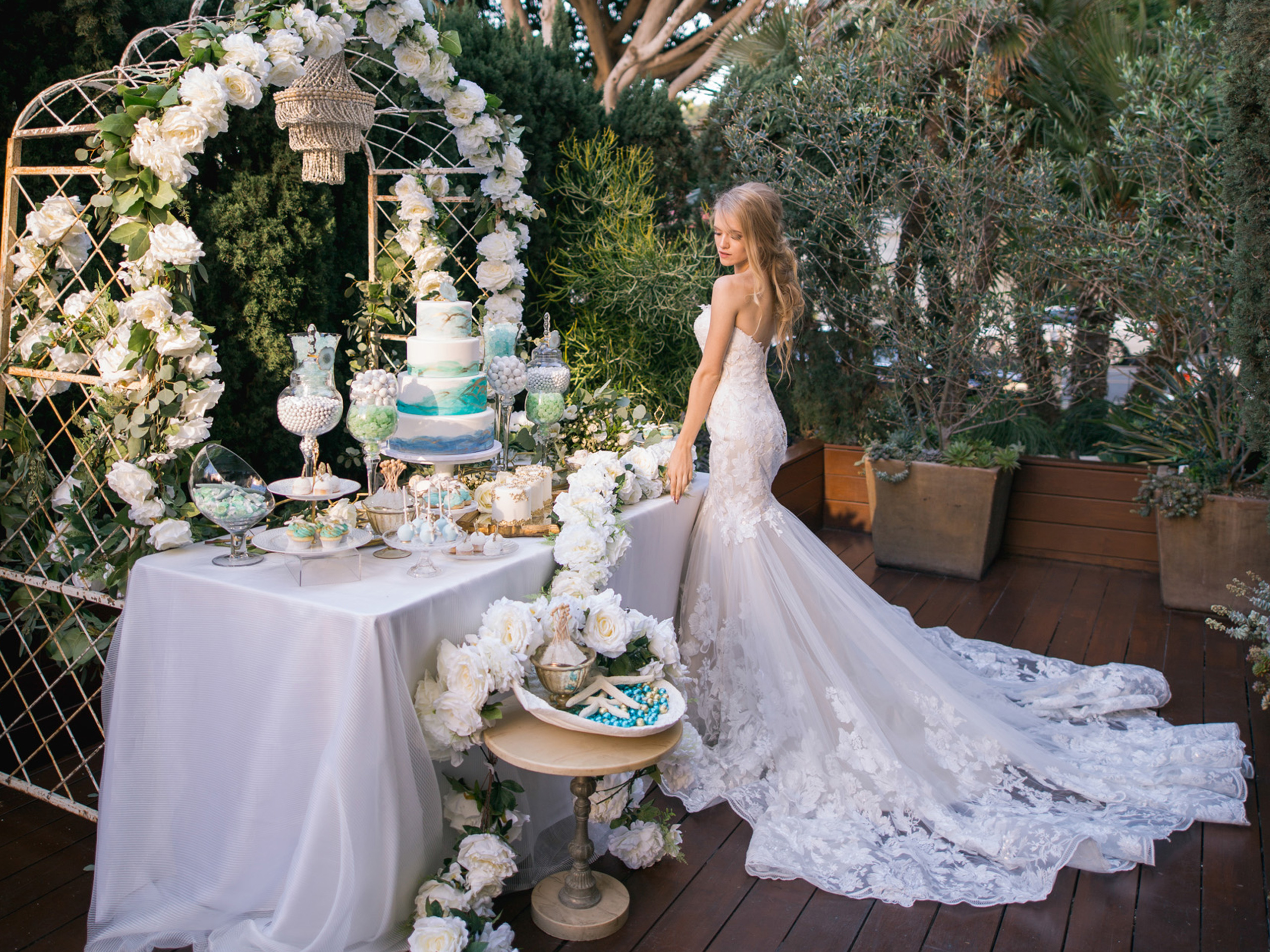 a bride standing next to the cake table