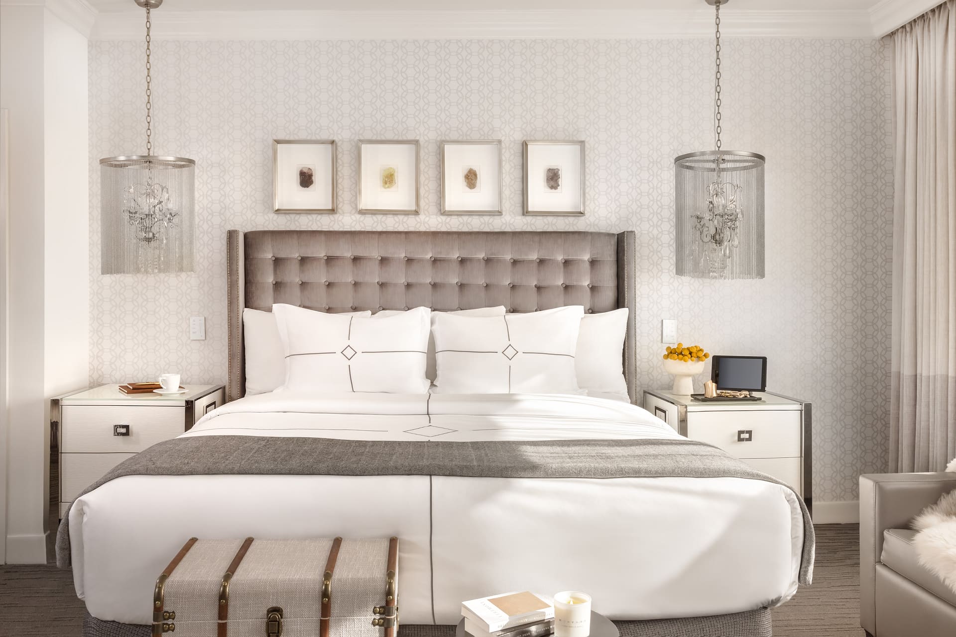 Plush king bed with white linens and pendant lights.