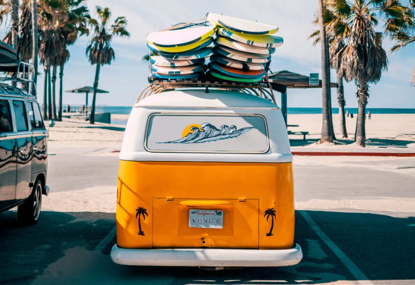 Retro van with surfboards parked by Venice Beach.