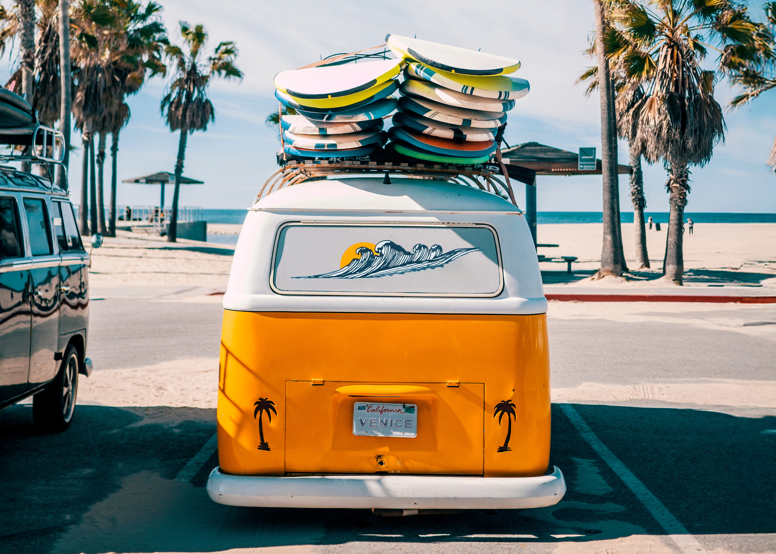 Retro van with surfboards parked by Venice Beach.