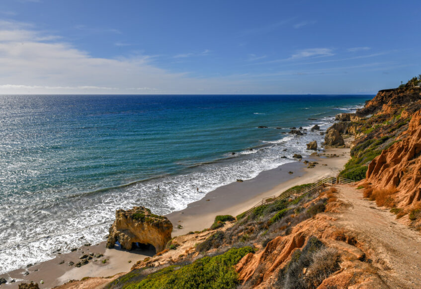 Scenic coastal cliffs and beach along Malibu shoreline.