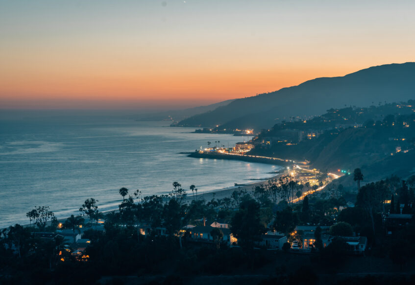 Malibu coastline illuminated at dusk with ocean view.