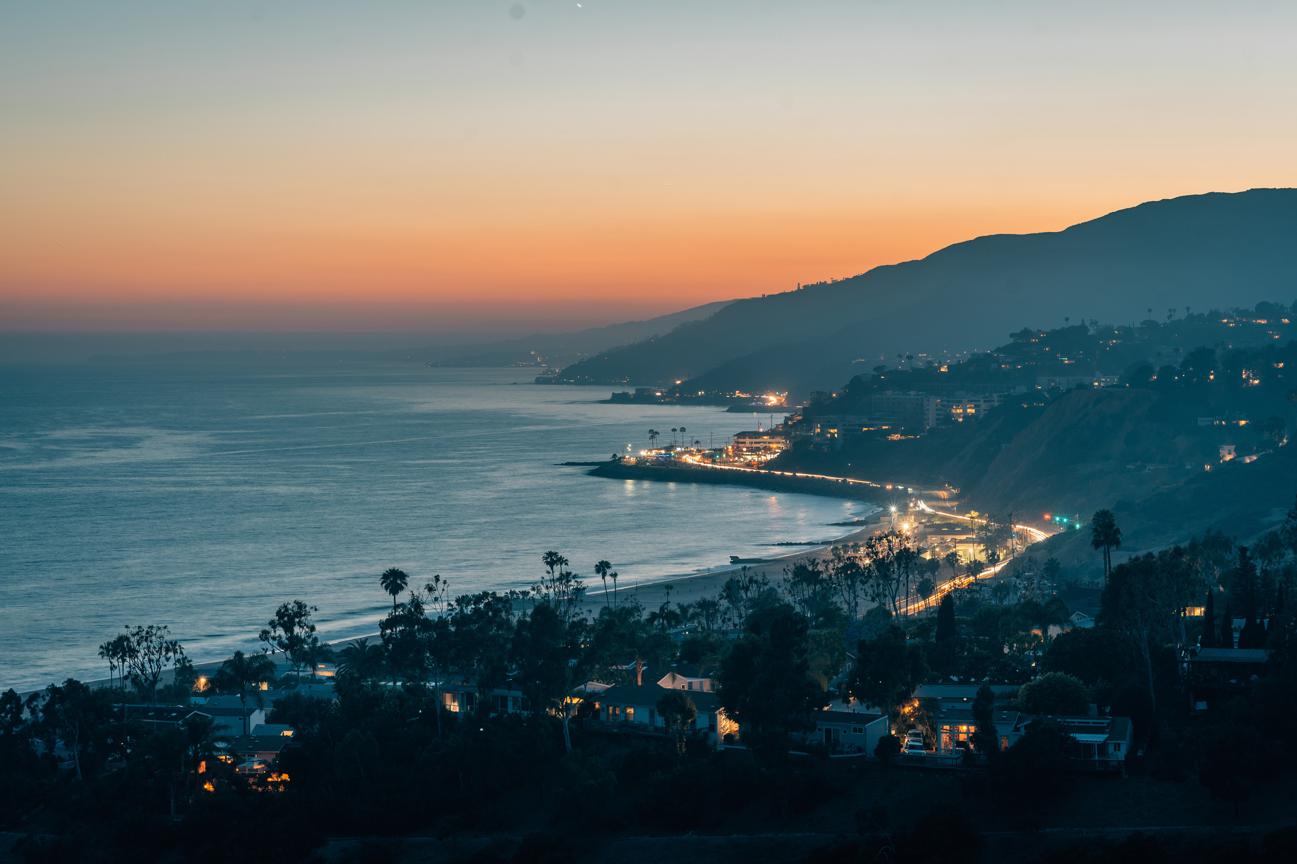 Malibu coastline illuminated at dusk with ocean view.