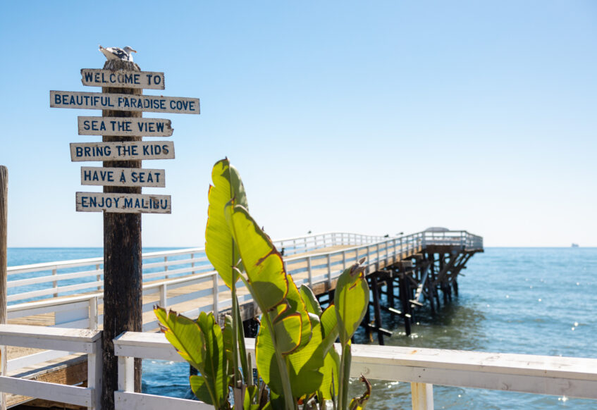 Paradise Cove pier with sign welcoming visitors to Malibu.