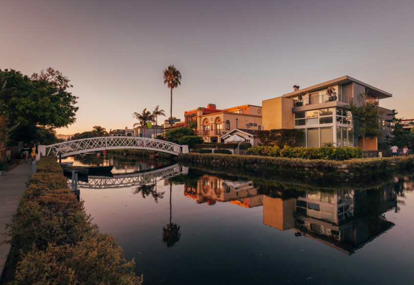 Peaceful Venice Canals with bridge and waterfront homes.
