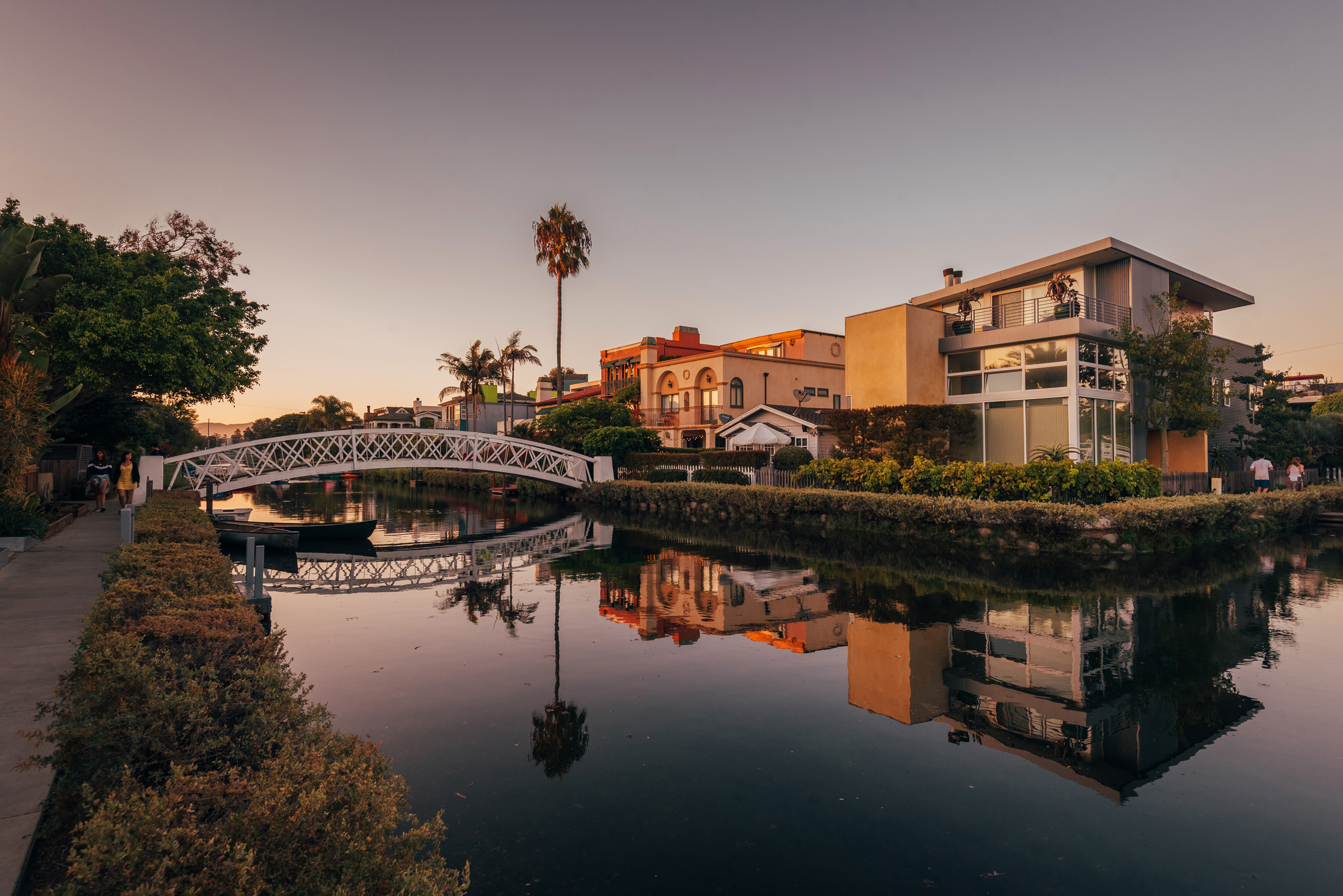 Peaceful Venice Canals with bridge and waterfront homes.