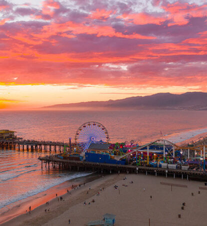 Santa Monica Pier at sunset over the ocean.