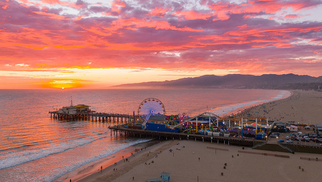 Santa Monica Pier at sunset over the ocean.