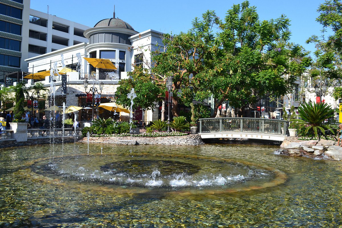 Outdoor shopping area with fountain, bridge, and greenery at The Grove in Los Angeles